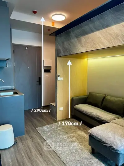 Modern compact living room with stylish sofa and kitchenette in urban apartment