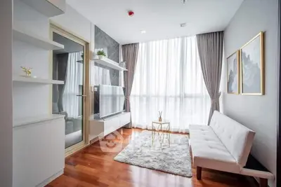 Modern living room with elegant decor, large window, and stylish furniture in a bright apartment.