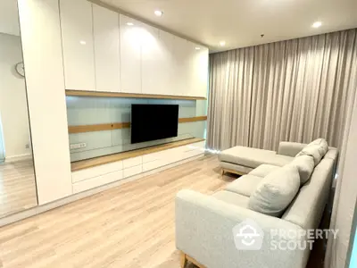 Modern living room with sleek white cabinetry and cozy gray sectional sofa