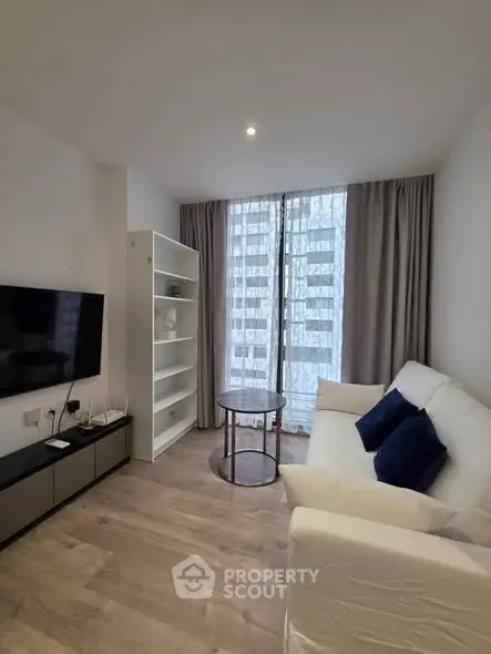 Modern living room with sleek furniture and large windows in a stylish apartment.