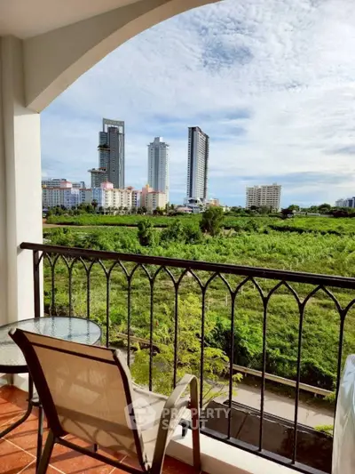 Stunning balcony view of lush greenery and modern city skyline, perfect for relaxation.