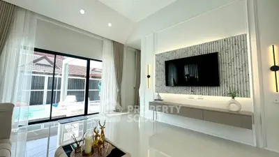 Luxurious living room with modern decor and pool view, perfect for relaxation and entertainment.