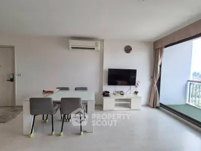 Modern living room with city view, featuring sleek furniture and large windows for natural light.