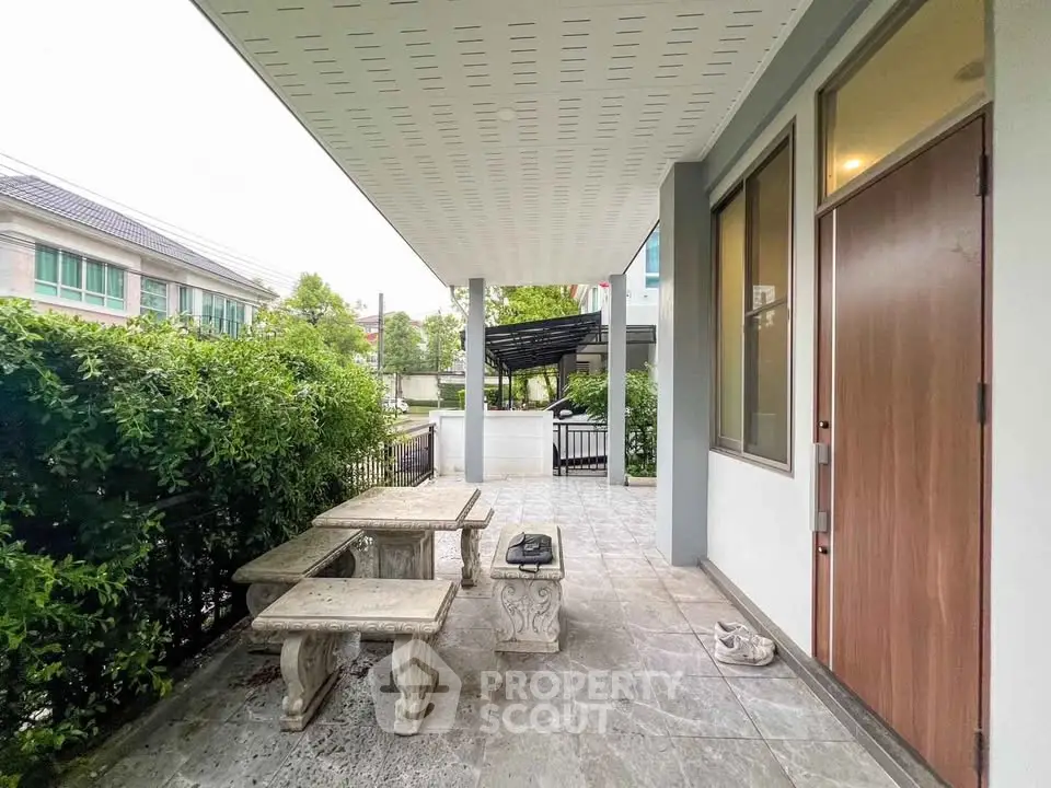 Charming outdoor patio with stone table and benches, perfect for relaxing in a serene garden setting.