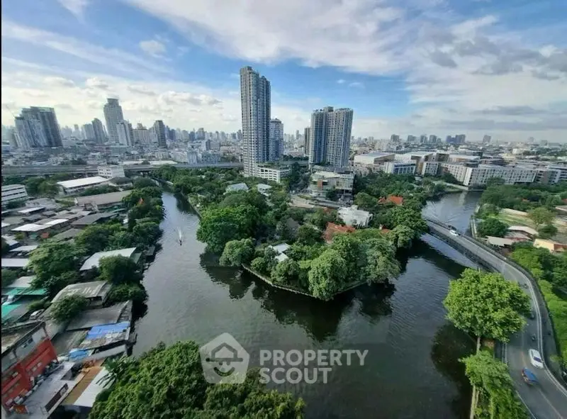 Stunning cityscape view with lush greenery and river, showcasing urban living amidst nature.