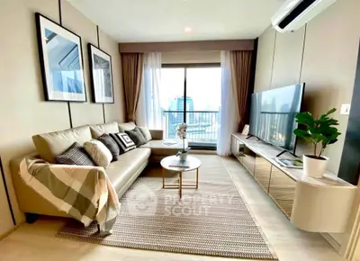 Modern living room with stylish decor and city view, featuring a comfortable sofa and large TV.