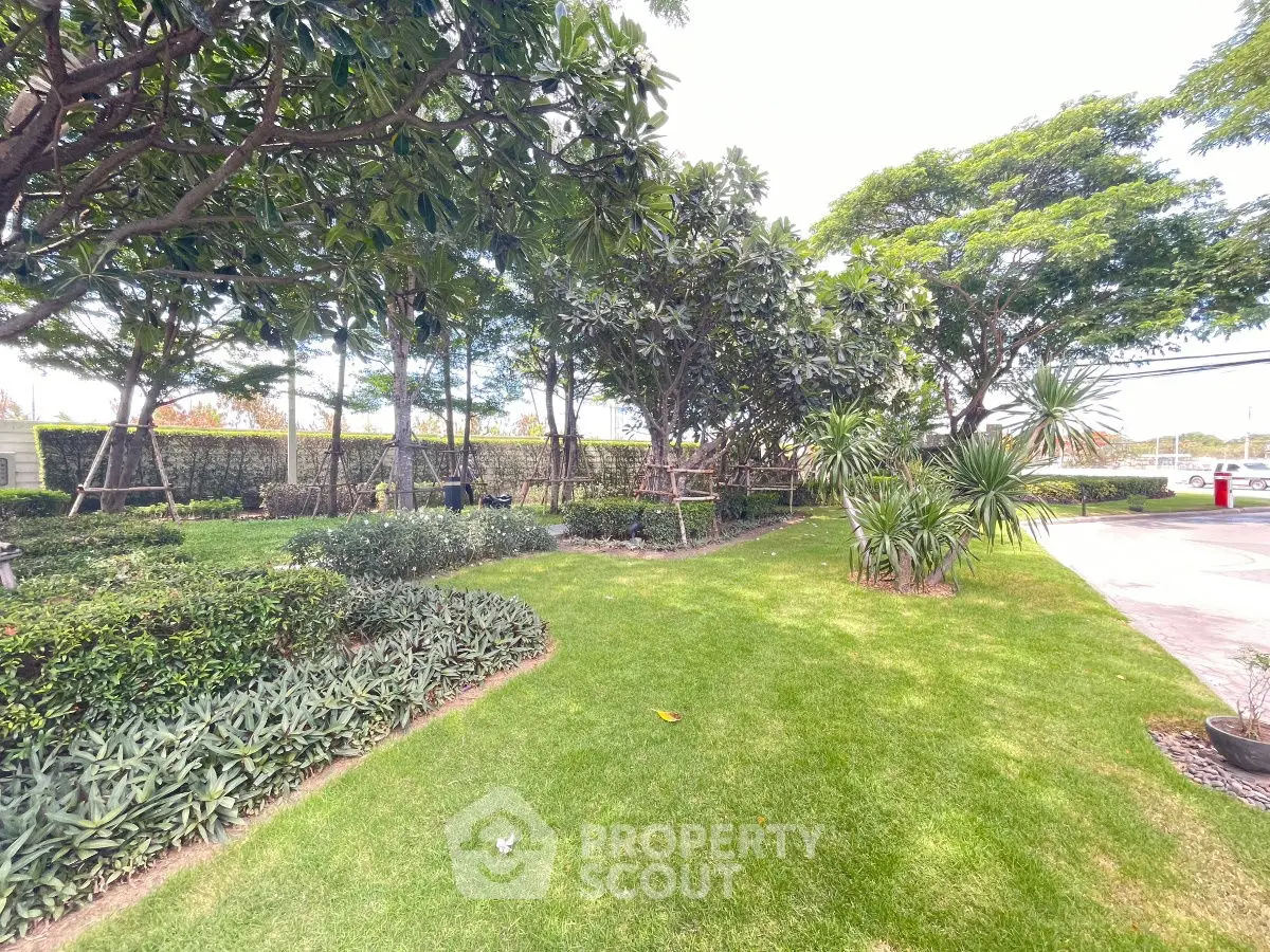 Lush green garden with manicured lawns and trees in a serene residential area.