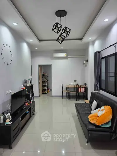 Modern living room with sleek black furniture and stylish lighting