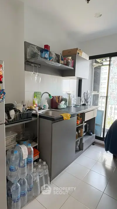 Compact kitchen with open shelving and large window in modern apartment