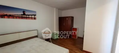 Cozy bedroom with wooden flooring and modern furniture in a serene setting.