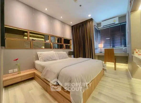 Modern bedroom with stylish decor and natural light, featuring a cozy bed and elegant furnishings.