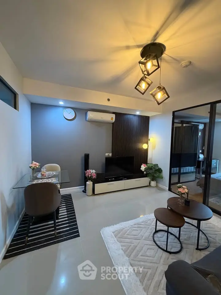 Modern living room with stylish decor, featuring a cozy seating area and elegant lighting.