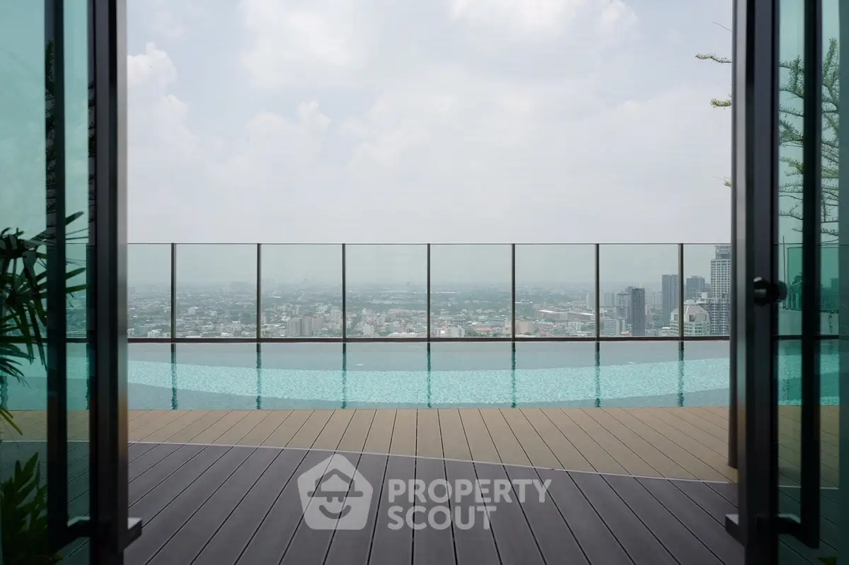 Stunning rooftop pool with panoramic city views and modern glass railing.