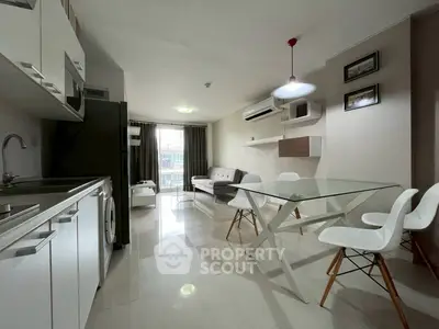 Modern open-plan living and kitchen area with sleek furniture and natural light.