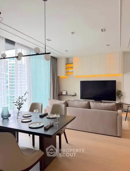 Modern living room with dining area, large windows, and stylish decor in a contemporary apartment.