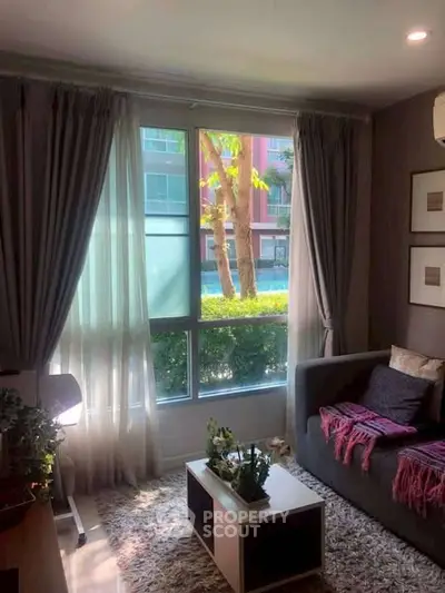 Cozy living room with large window and stylish decor in modern apartment.