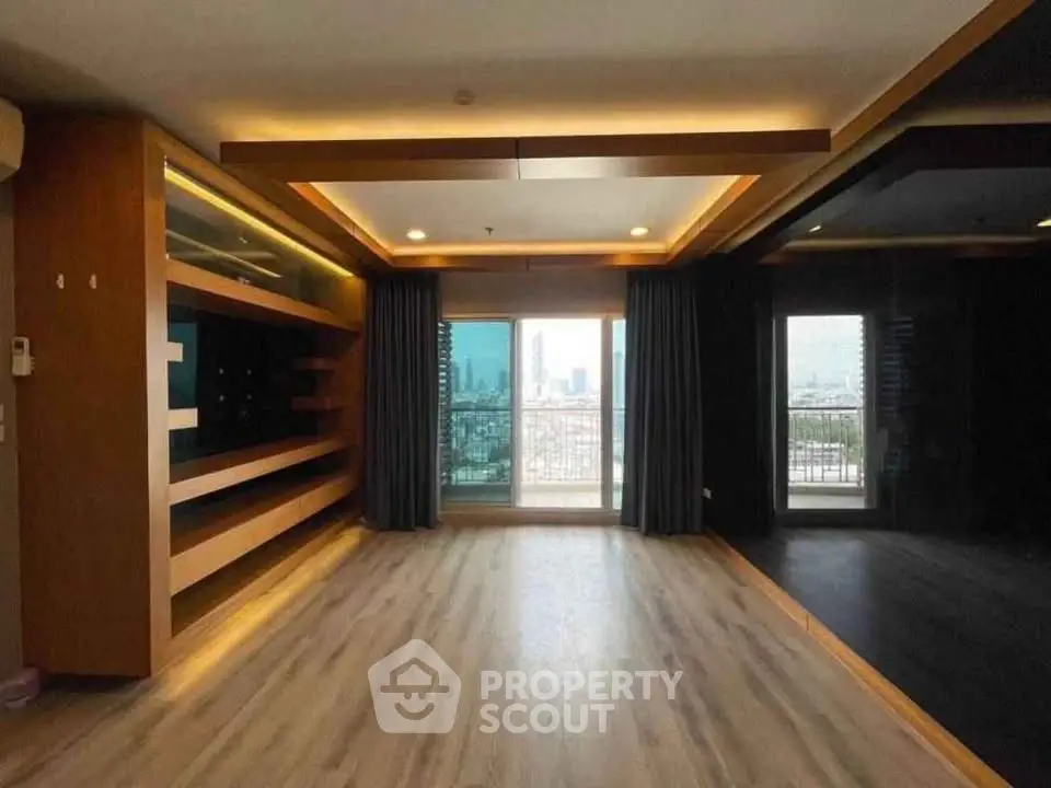 Spacious modern living room with large windows and city view, featuring elegant wooden flooring and ambient lighting.
