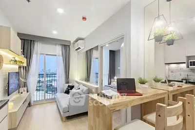 Modern open-plan living room with kitchen and balcony view, featuring stylish decor and natural light.