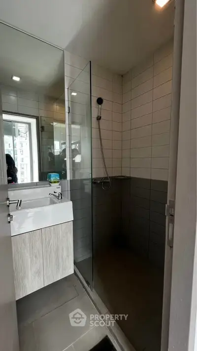 Modern bathroom with sleek shower and stylish vanity in contemporary apartment.