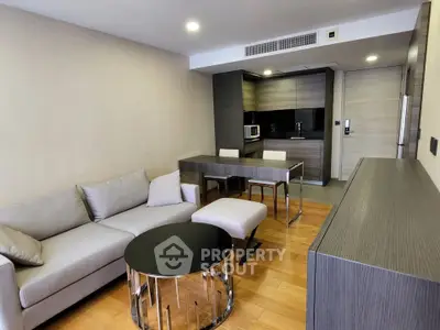 Modern living room with sleek furniture and open kitchen layout in a stylish apartment.