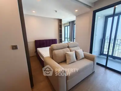 Modern bedroom with balcony view and cozy seating area in luxury apartment