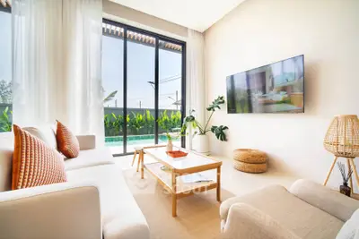 Bright and modern living room with pool view, featuring cozy seating and stylish decor.