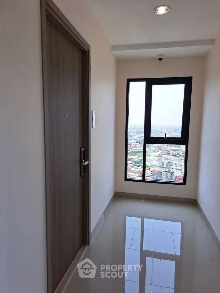 Modern apartment corridor with city view through large window, sleek door and glossy floor tiles.