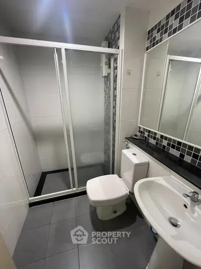 Modern bathroom with sleek shower enclosure and stylish black and white tiles.