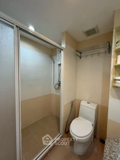 Modern bathroom with shower enclosure and toilet in a stylish apartment.
