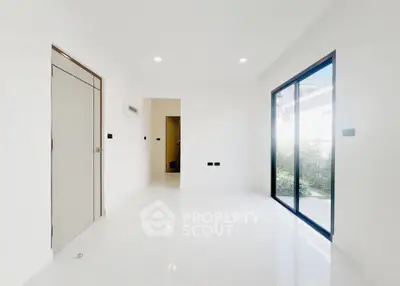 Spacious modern interior with large windows and sleek white flooring, perfect for natural light lovers.