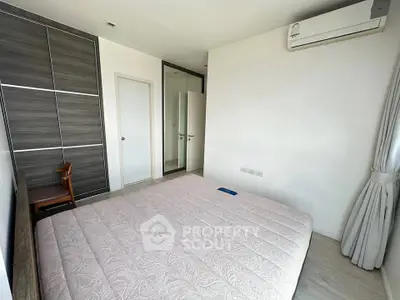 Modern bedroom with sleek design, featuring a large bed, built-in wardrobe, and air conditioning unit.