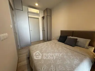 Cozy bedroom with modern decor and ample storage in a stylish apartment.