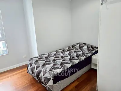 Cozy bedroom with modern geometric bedding and hardwood floors
