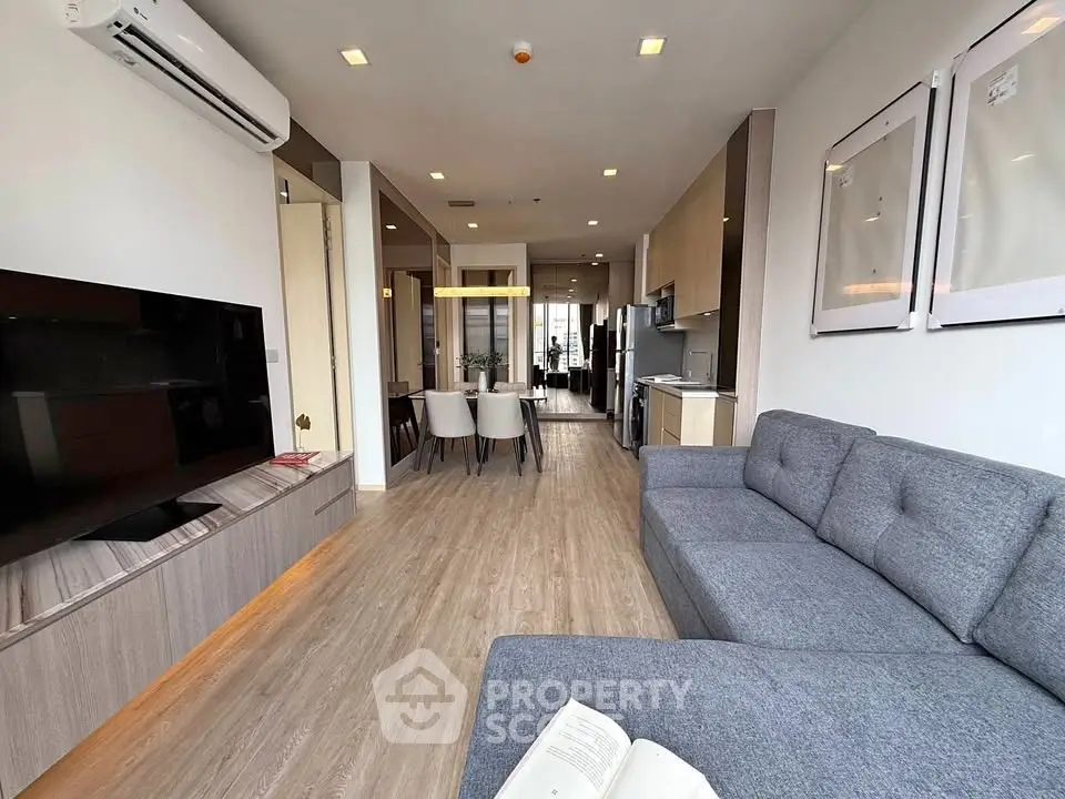 Modern living room with open layout, featuring stylish furniture and sleek design, perfect for urban living.
