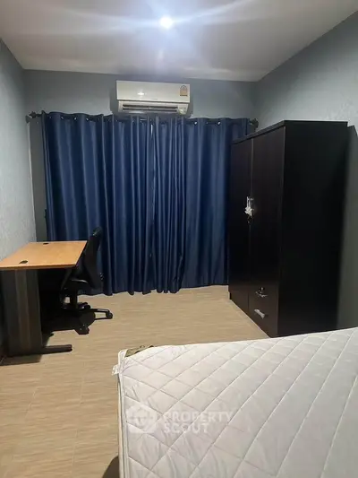 Cozy bedroom with air conditioning, dark curtains, and modern furniture for a comfortable living experience.