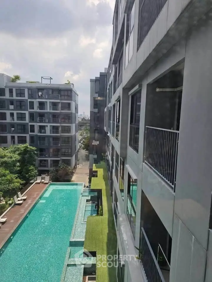 Modern apartment complex with a stunning outdoor pool and lush greenery, offering a luxurious urban living experience.