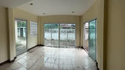 Spacious room with large windows offering abundant natural light and garden view, ideal for customization.