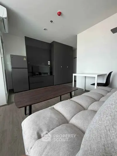 Modern living room with sleek furniture and open layout, featuring a cozy sofa and stylish coffee table.
