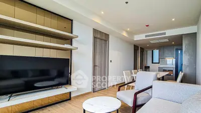 Modern living room with sleek furniture and open kitchen layout in a stylish apartment.