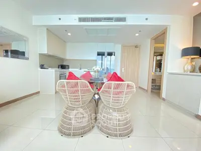 Modern open-layout kitchen and dining area with stylish wicker chairs and sleek appliances.