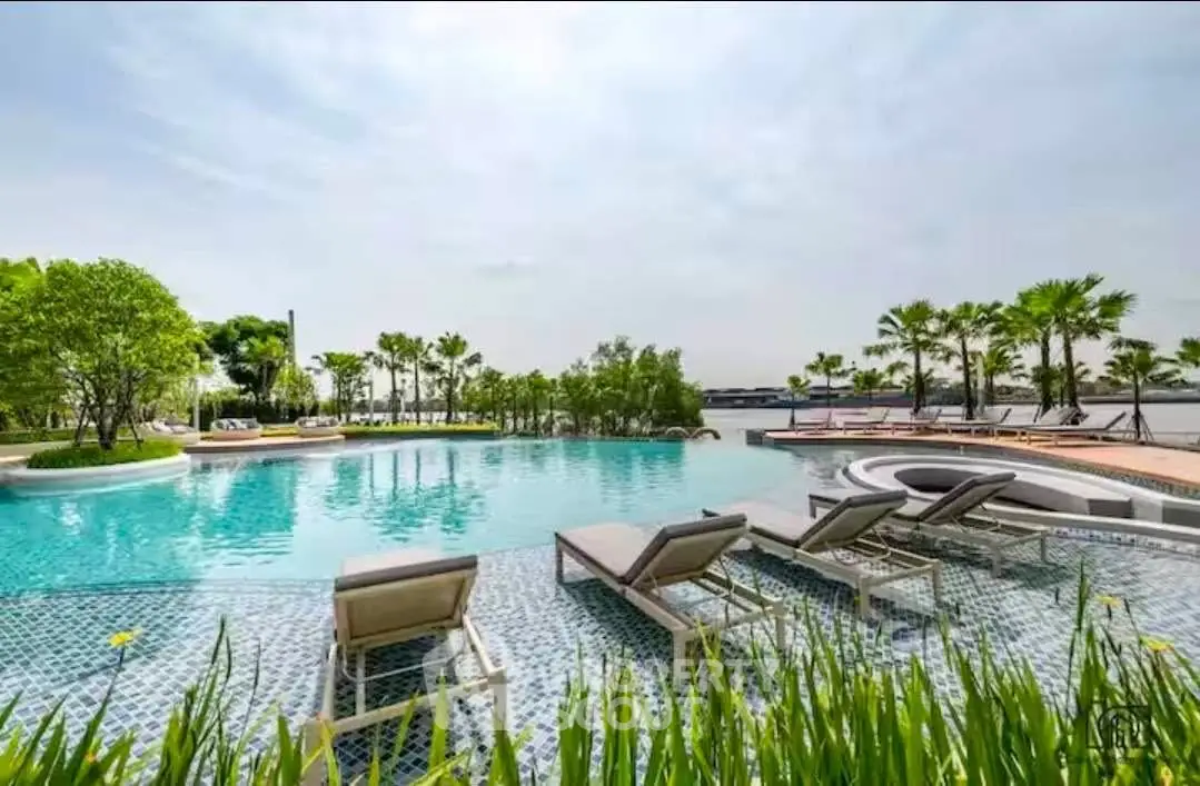 Luxurious outdoor pool with sun loungers and lush greenery, perfect for relaxation and leisure.