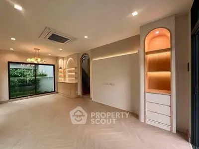 Spacious modern living room with built-in shelves and large window view.