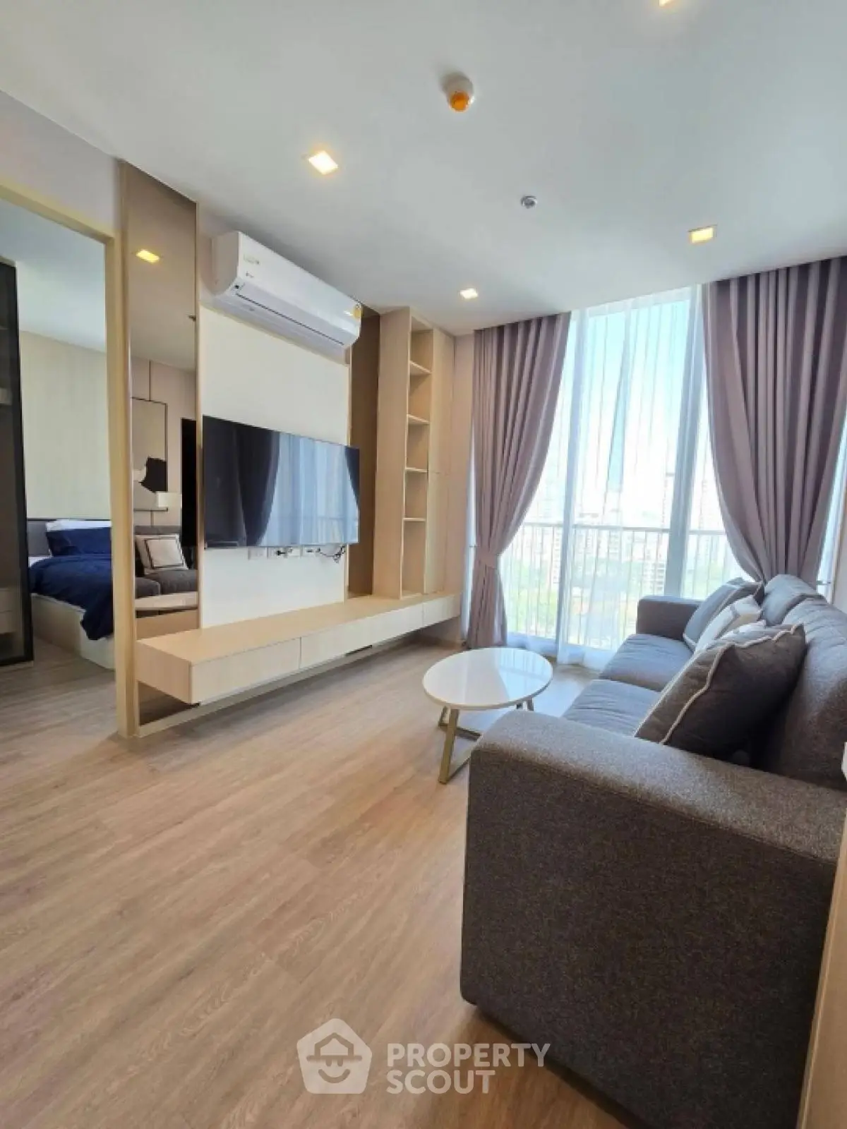 Modern living room with stylish decor and large windows offering natural light.