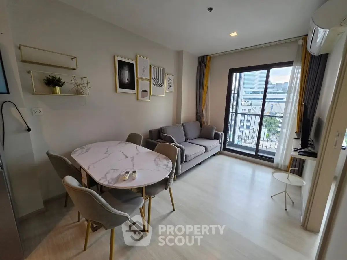 Modern living room with stylish decor and balcony view in a high-rise apartment.
