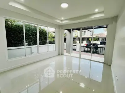 Spacious modern living room with large windows and glossy tile flooring