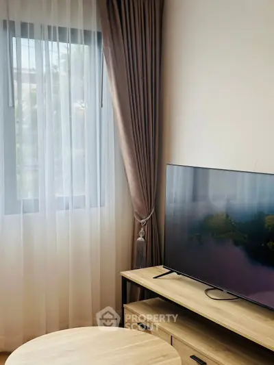 Modern living room with sleek TV and elegant curtains