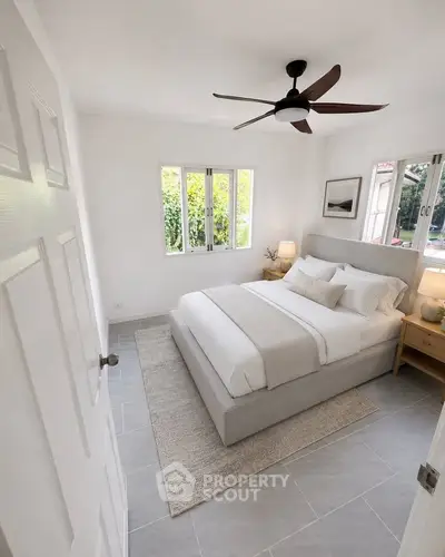Bright and cozy bedroom with modern decor and garden view, perfect for relaxation.