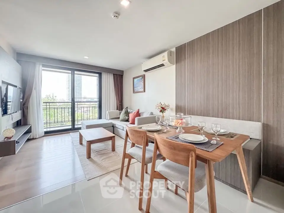 Modern living room with dining area and balcony view in a stylish apartment.