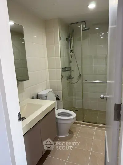 Modern bathroom with glass shower and sleek fixtures in contemporary apartment