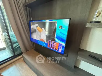 Modern living room with wall-mounted TV and sliding glass door to balcony
